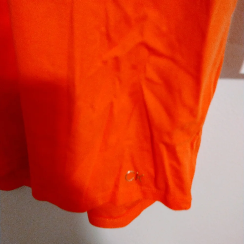 NWOT Calvin Klein orange short sleeve top with half button front detail.  Size